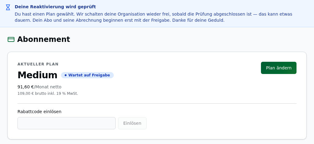 Abonnement-Seite einer gesperrten Organisation nach der Planwahl: oben der blaue Hinweis „Deine Reaktivierung wird geprüft", darunter die Status-Card mit Plan „Medium" und dem Status „Wartet auf Freigabe", Preiszeile „91,60 €/Monat netto", dem Knopf „Plan ändern" und dem Feld „Rabattcode einlösen"