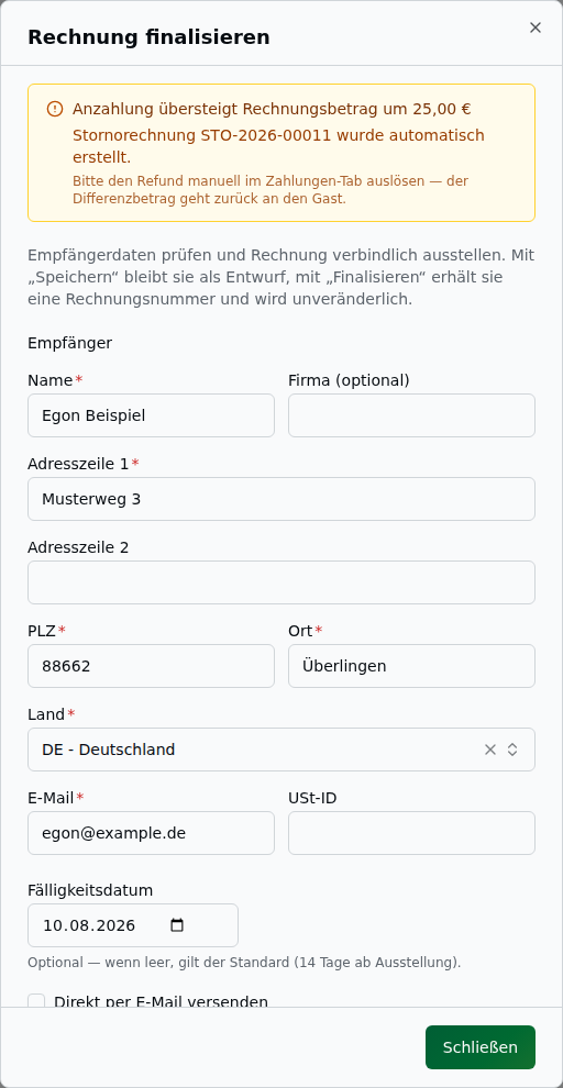 Amber-farbener Banner im Finalisieren-Dialog nach dem Ausstellen – Hinweis „Anzahlung übersteigt Rechnungsbetrag um 25,00 €", die automatisch erstellte Stornorechnungsnummer (STO-2026-…), der Hinweis zum noch im Zahlungen-Tab auszulösenden Refund und ein einzelner „Schließen"-Button